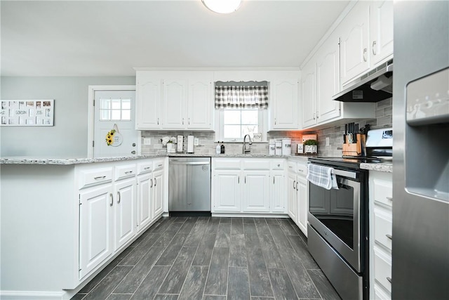 kitchen featuring appliances with stainless steel finishes, a healthy amount of sunlight, white cabinets, and under cabinet range hood