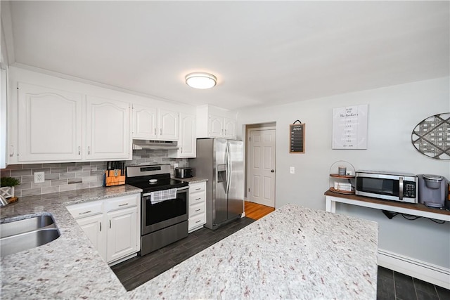 kitchen featuring under cabinet range hood, a sink, white cabinetry, appliances with stainless steel finishes, and backsplash