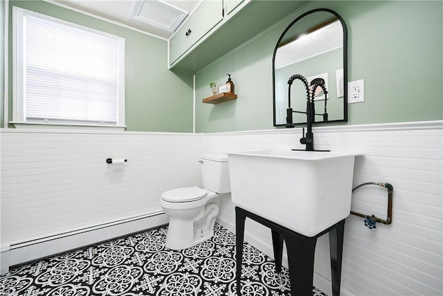 half bath featuring toilet, a wainscoted wall, a baseboard radiator, and tile patterned flooring