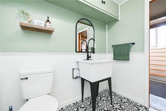 bathroom featuring wainscoting and toilet