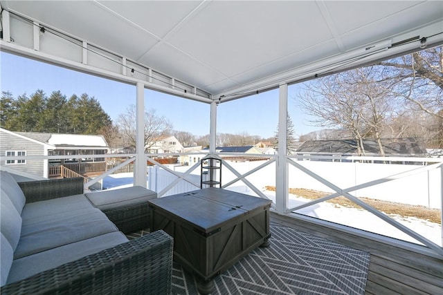 sunroom featuring vaulted ceiling and a residential view