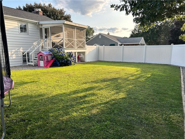 view of yard with a fenced backyard and a sunroom