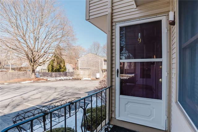 doorway to property featuring fence