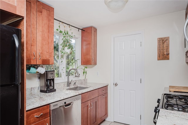 kitchen with light stone counters, brown cabinetry, a sink, and black appliances