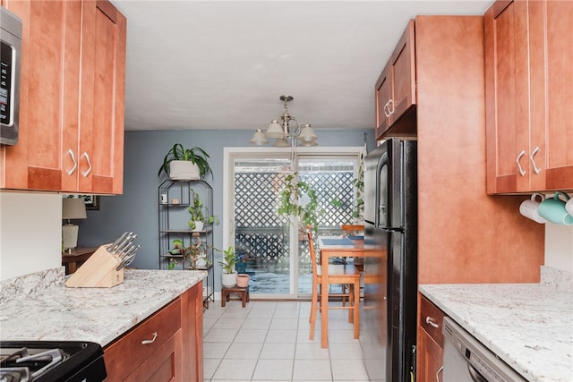 kitchen featuring light stone countertops, brown cabinetry, stainless steel appliances, and an inviting chandelier