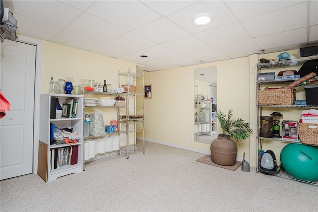 interior space with a drop ceiling and baseboards