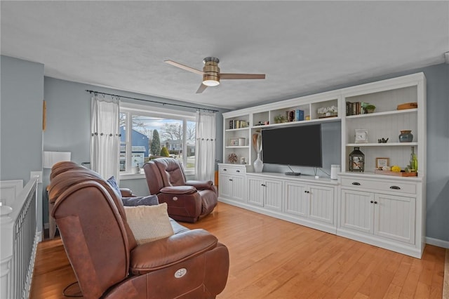 living area with light wood-style flooring and a ceiling fan