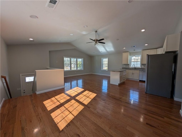 unfurnished living room featuring lofted ceiling, baseboards, visible vents, and dark wood-type flooring