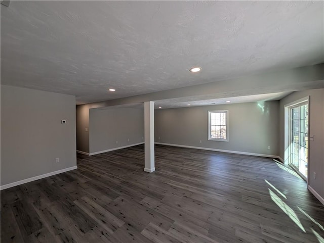 below grade area featuring a textured ceiling, baseboards, wood finished floors, and recessed lighting