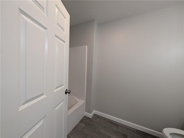 full bath featuring wood finished floors, toilet, and baseboards