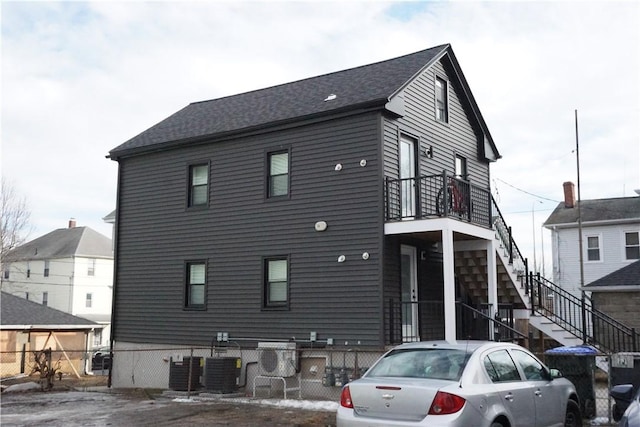 view of front of house with central air condition unit, fence, and stairs