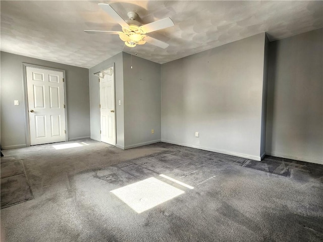 carpeted spare room featuring ceiling fan and baseboards