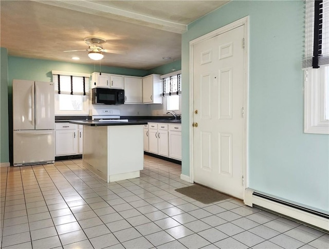 kitchen featuring white appliances, white cabinetry, baseboard heating, a center island, and dark countertops