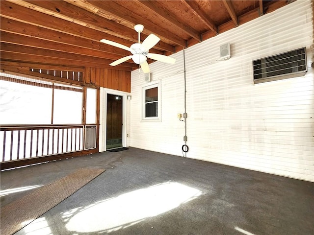 unfurnished sunroom featuring beamed ceiling and ceiling fan