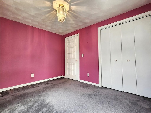 unfurnished bedroom with a closet, carpet flooring, and baseboards