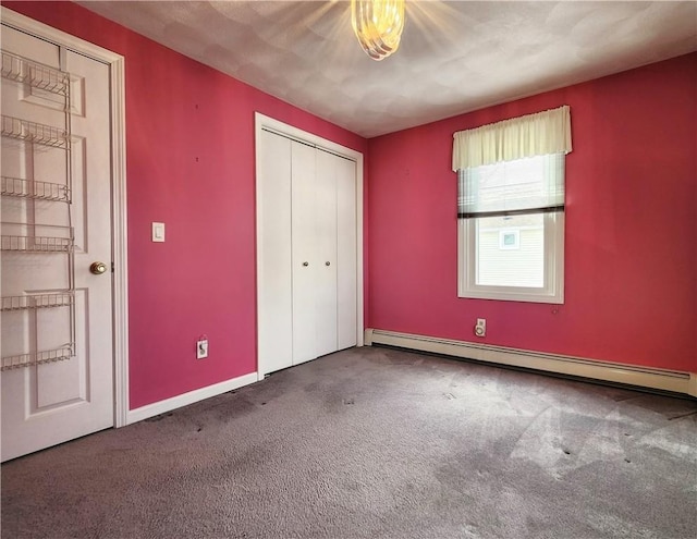 unfurnished bedroom featuring carpet floors, a baseboard radiator, baseboards, and a closet