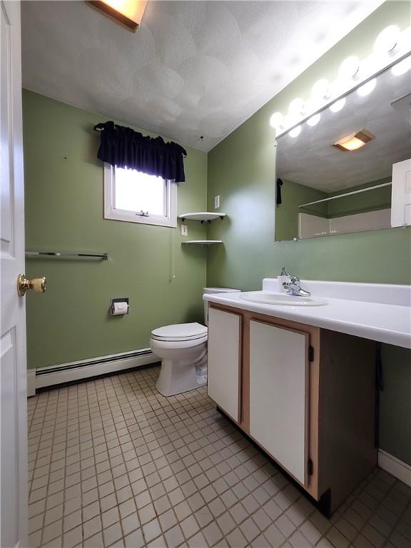 bathroom with toilet, a baseboard radiator, a textured ceiling, and vanity