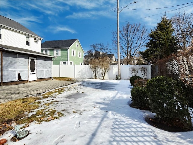 yard layered in snow featuring a fenced backyard