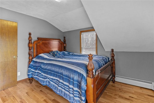 bedroom with lofted ceiling, a baseboard radiator, light wood-style flooring, and baseboards