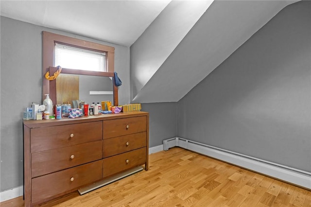 additional living space with lofted ceiling, light wood finished floors, a baseboard radiator, and baseboards