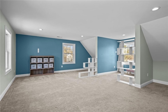 additional living space featuring lofted ceiling, light carpet, visible vents, and baseboards