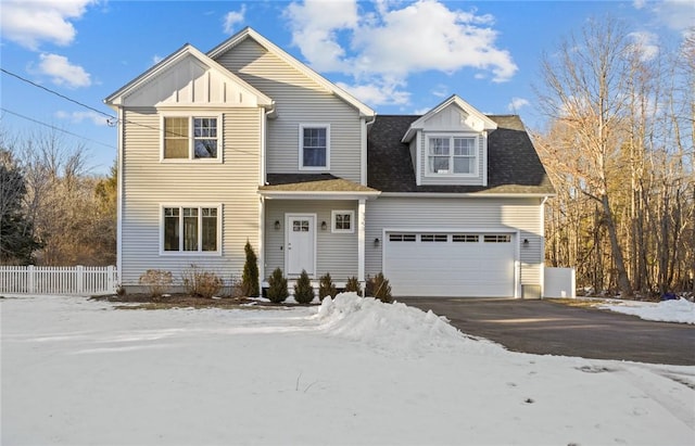 view of front of home featuring roof with shingles, board and batten siding, fence, a garage, and driveway