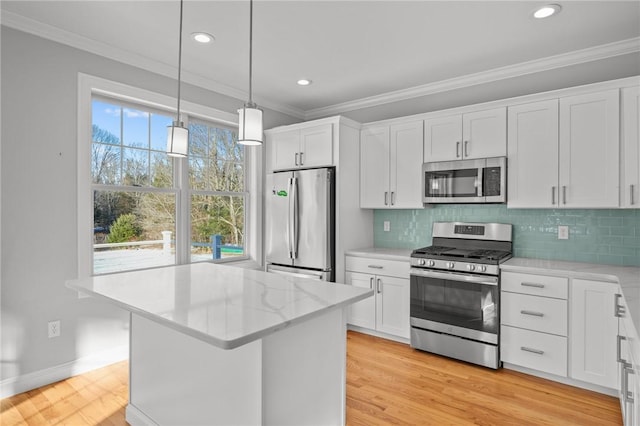 kitchen with light wood finished floors, white cabinetry, appliances with stainless steel finishes, and ornamental molding