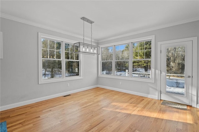 unfurnished dining area featuring light wood-type flooring, visible vents, and crown molding