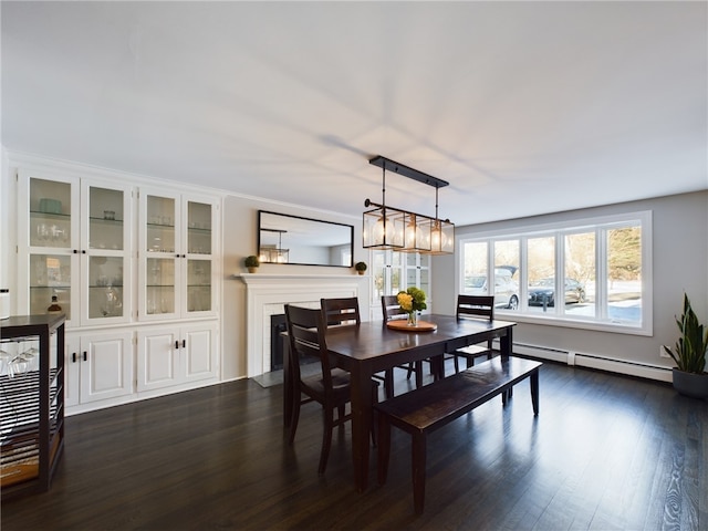 dining area featuring dark wood-style flooring, a baseboard radiator, and a glass covered fireplace