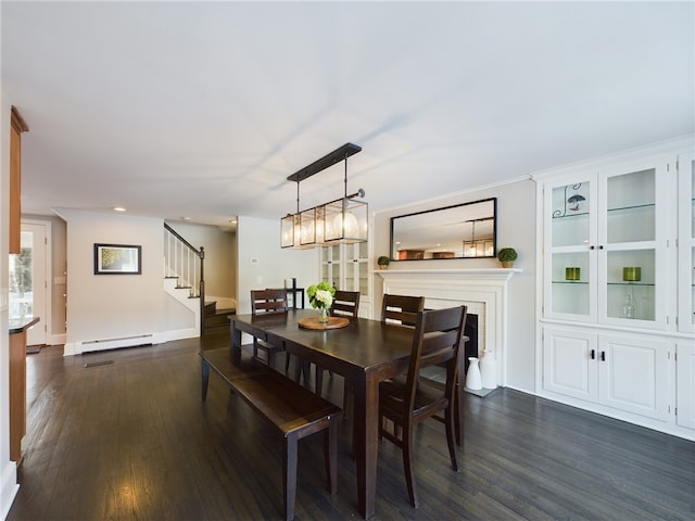 dining space featuring dark wood-style floors, a baseboard radiator, baseboards, and stairs