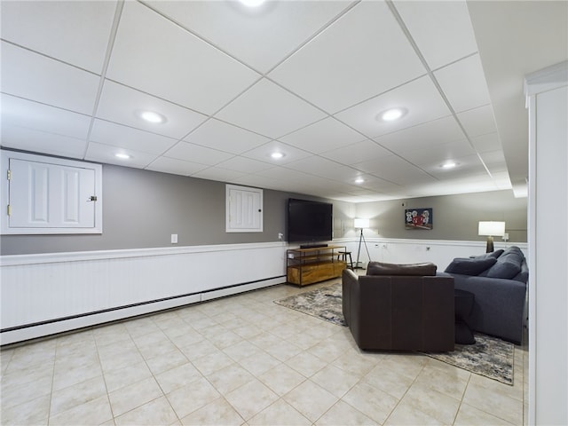 living room with recessed lighting, a wainscoted wall, a drop ceiling, and a baseboard radiator