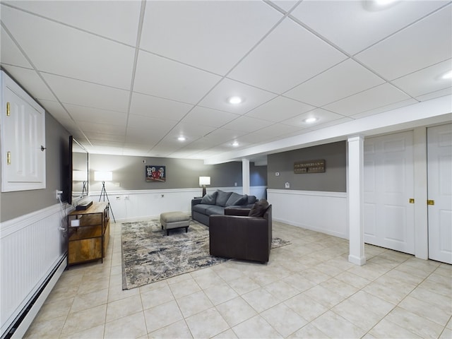 living area featuring recessed lighting, a baseboard radiator, a drop ceiling, and wainscoting