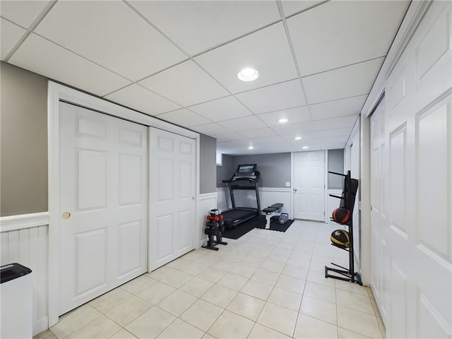 workout area with recessed lighting, wainscoting, a drop ceiling, and light tile patterned floors