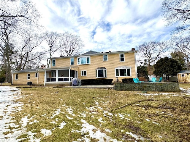 rear view of house featuring a sunroom and a chimney