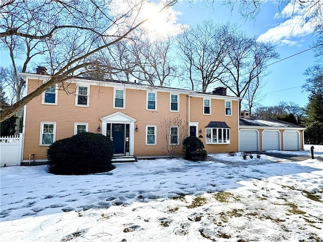 colonial inspired home featuring fence and a chimney