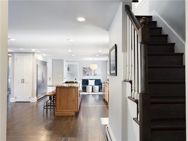 interior space with a baseboard radiator, wood finished floors, and recessed lighting