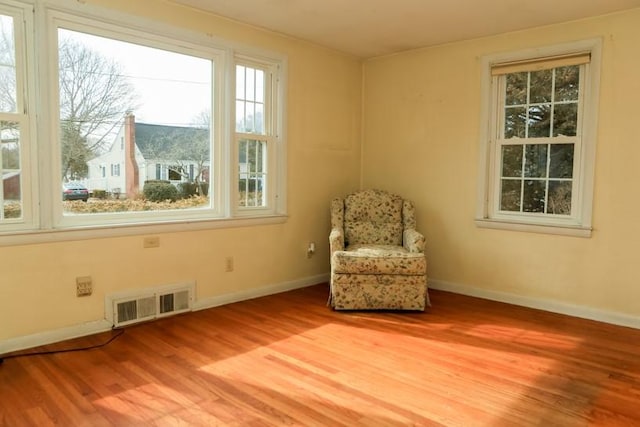 unfurnished room featuring visible vents, light wood-style flooring, and baseboards