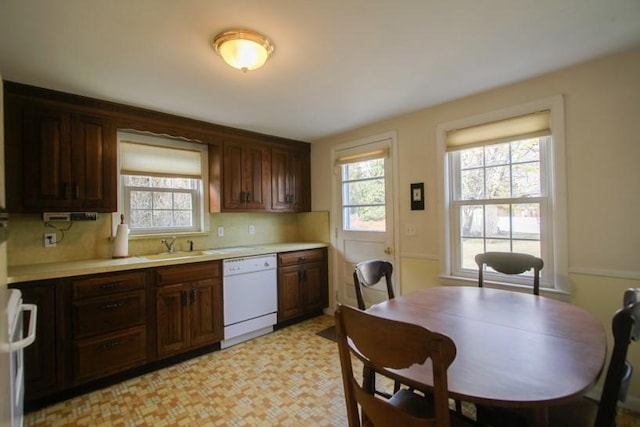 kitchen with range, plenty of natural light, white dishwasher, and light countertops