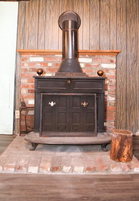 interior details featuring a wood stove and wood finished floors