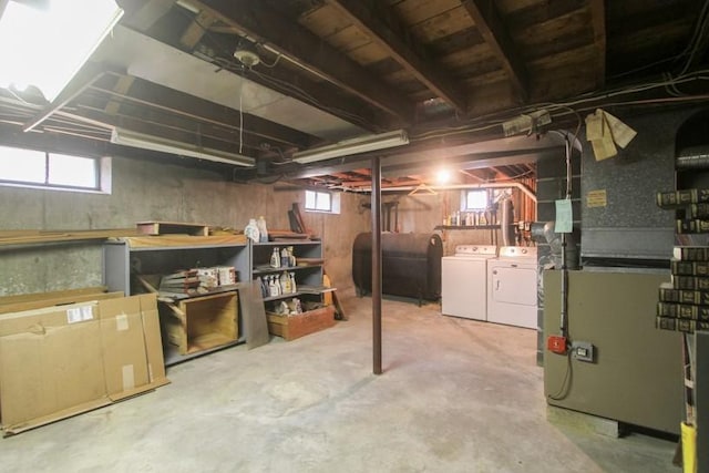 below grade area with heating unit, washer and clothes dryer, and heating fuel