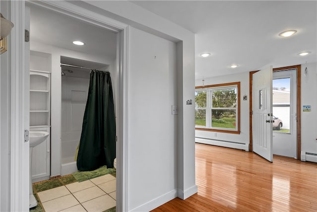 bathroom featuring recessed lighting, a baseboard heating unit, wood finished floors, baseboards, and baseboard heating