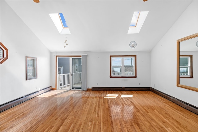 unfurnished living room with a baseboard heating unit, vaulted ceiling with skylight, light wood finished floors, and a baseboard radiator