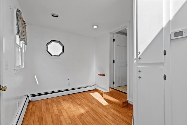 spare room with light wood-type flooring, a baseboard radiator, and recessed lighting