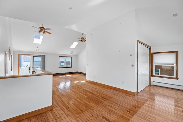 unfurnished living room featuring a skylight, baseboards, light wood-style floors, a baseboard heating unit, and high vaulted ceiling