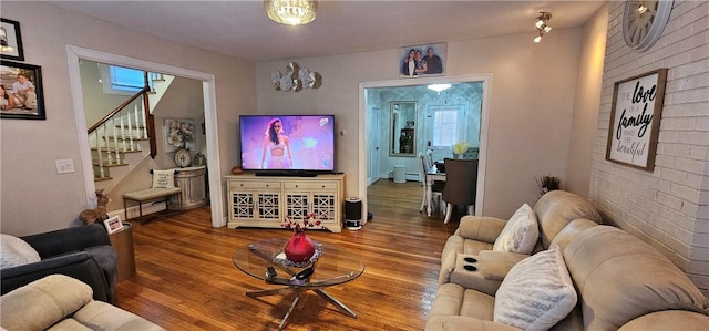 living area with stairway and wood finished floors