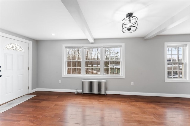 foyer entrance with radiator heating unit, baseboards, dark wood-style flooring, and beam ceiling