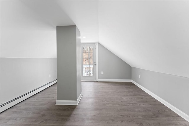 additional living space with lofted ceiling, baseboards, dark wood finished floors, and baseboard heating