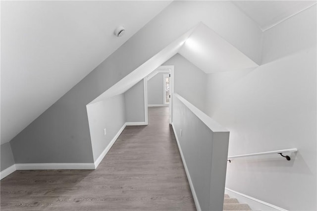 bonus room with vaulted ceiling, wood finished floors, and baseboards