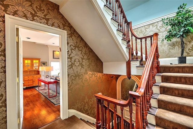 stairs featuring wallpapered walls, baseboards, and wood finished floors