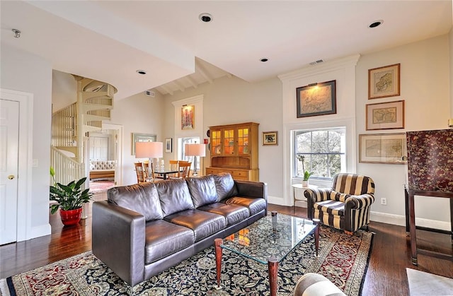 living room with stairs, baseboards, and dark wood-style flooring